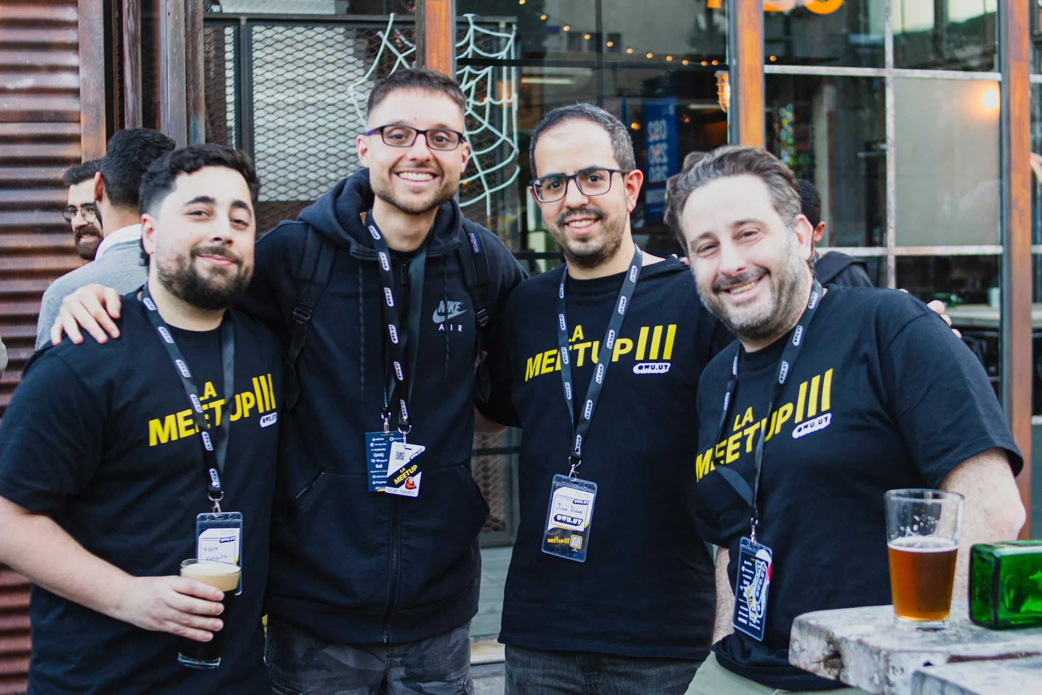 Cuatro organizadores con la remera de La Meetup brindando en el after