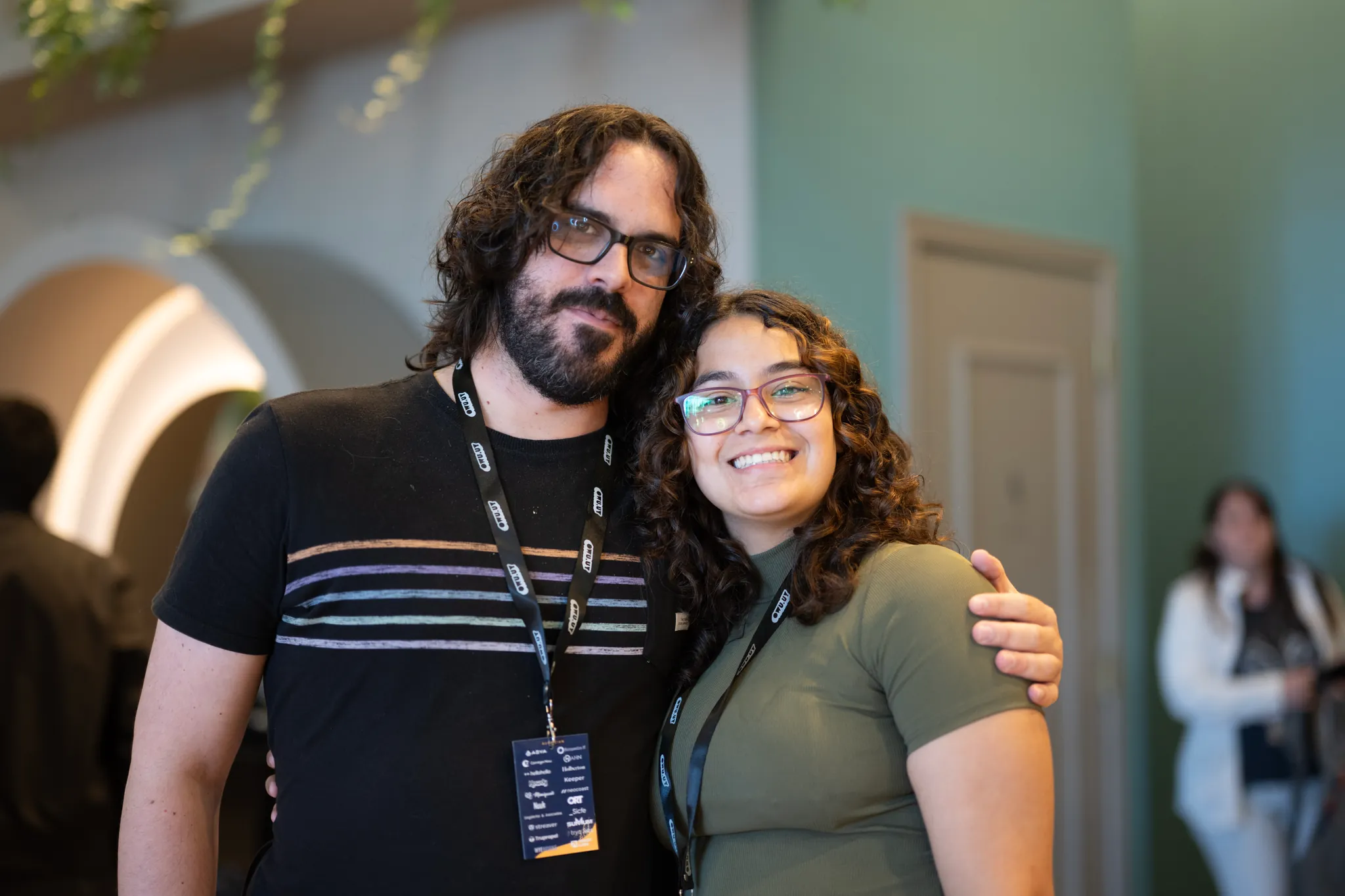 Dos asistentes abrazados y sonriendo para la foto