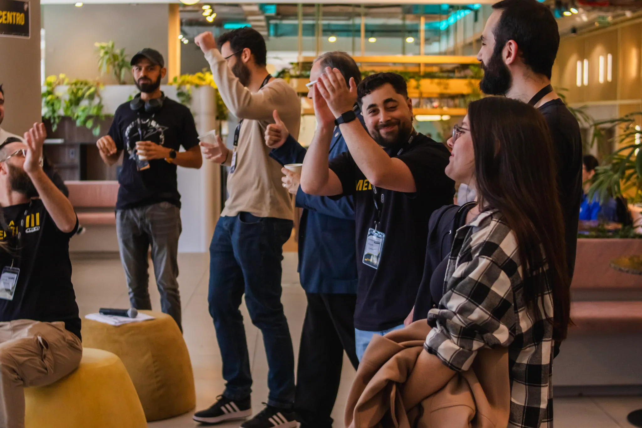 Un grupo de asistentes riéndose y aplaudiendo en el lobby